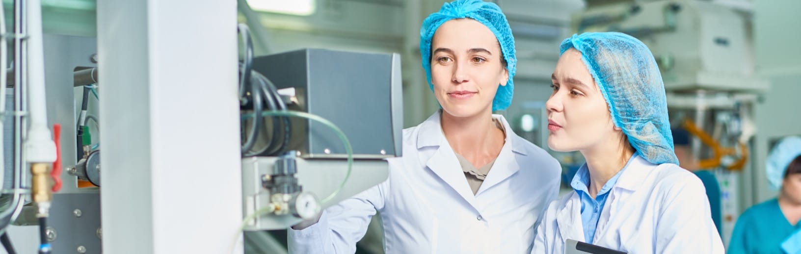 Production workers checking settings on machine