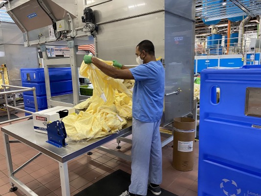 LHLS production worker inspecting PPE gowns